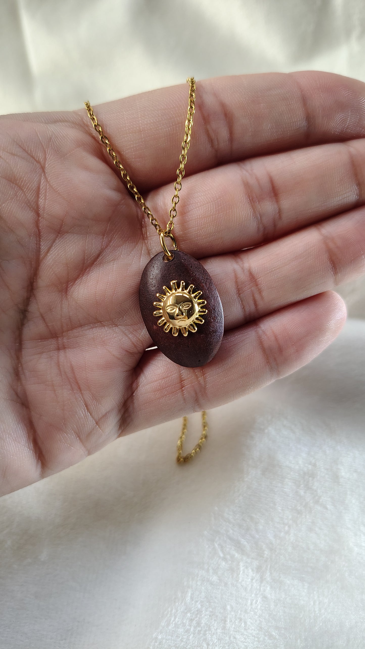 Collana con sole su base in legno